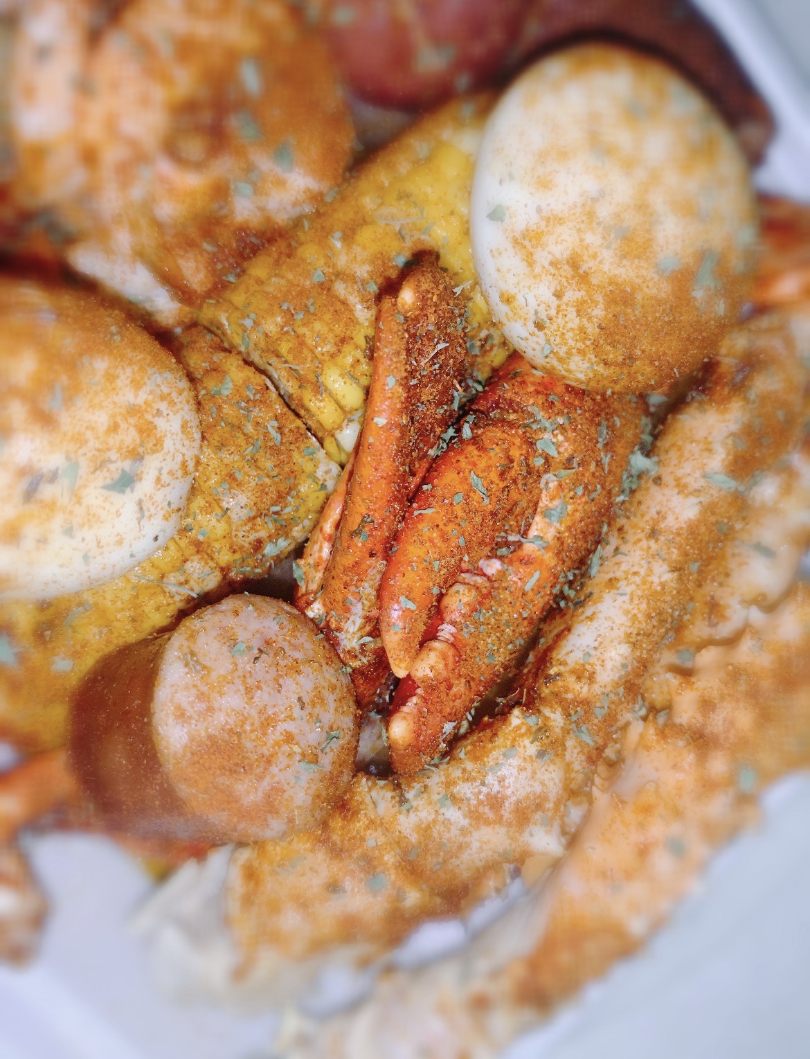 Seasoned seafood boil with crab, eggs and corn