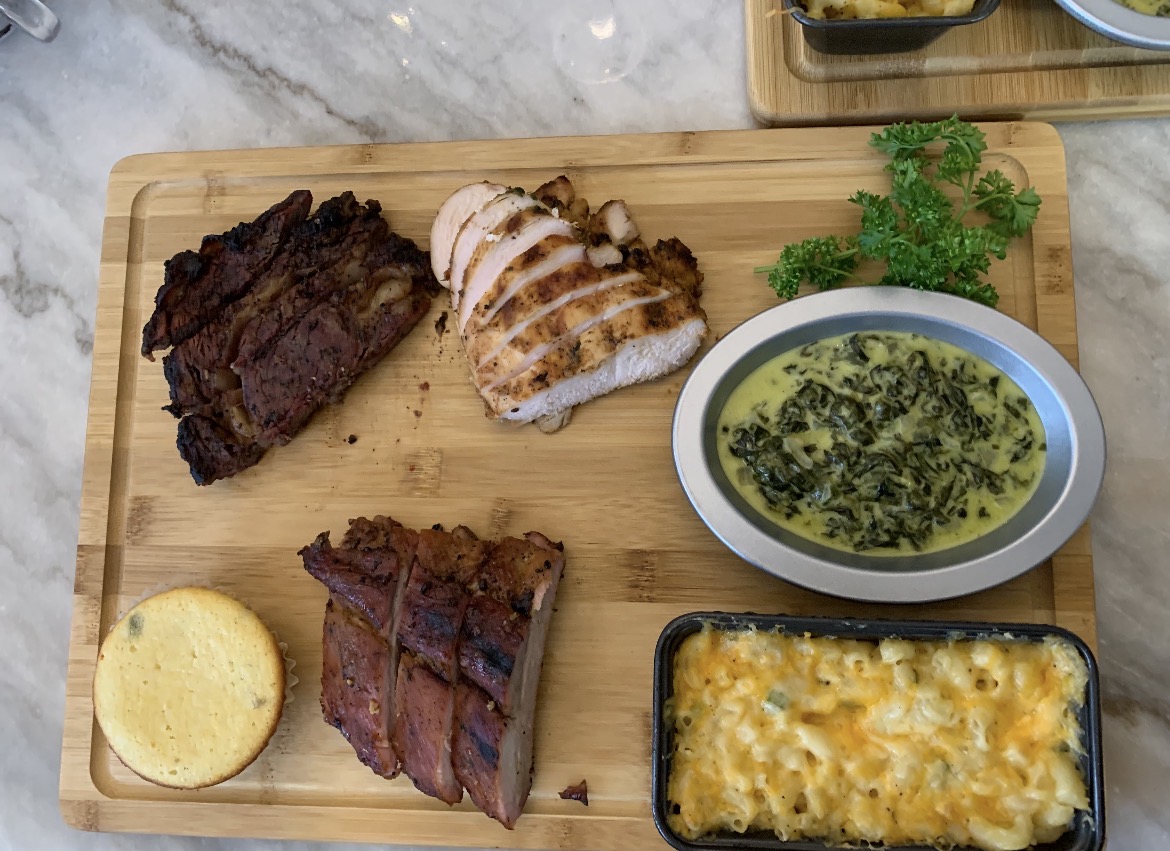 Grilled meats with creamed greens, macaroni and cornbread