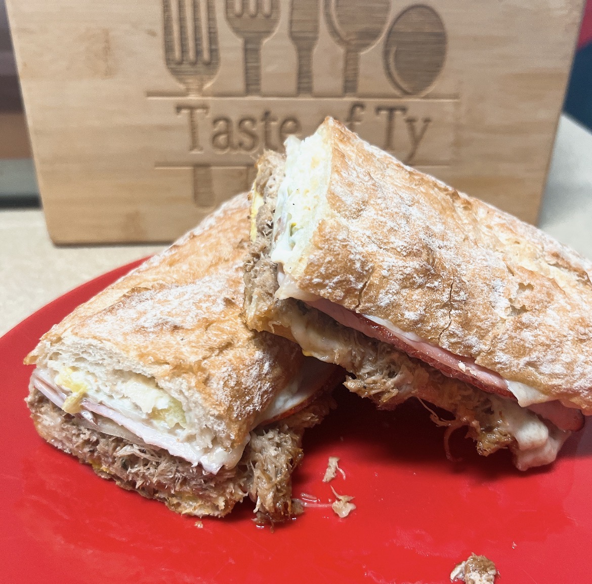 Chef-crafted pressed sandwich on a red plate